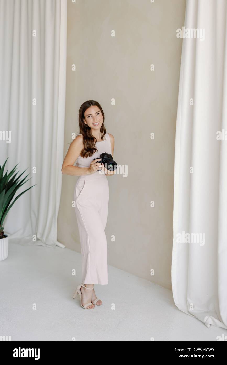 Photographe souriant avec l'appareil photo à la maison Banque D'Images