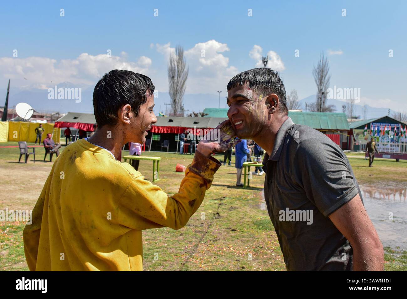 Srinagar, Cachemire. 25 mars 2024. Un garçon enduit de la poudre colorée sur le visage d'un soldat paramilitaire alors qu'ils célèbrent Holi, la fête hindoue des couleurs du printemps, dans un camp militaire de Srinagar. Crédit : SOPA images Limited/Alamy Live News Banque D'Images