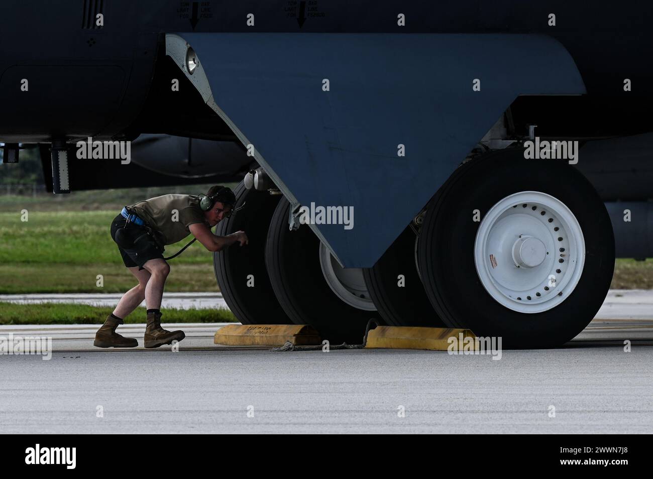 L'aviateur de l'US Air Force Robert Adams, un chef d'équipage de B-52 du 5th Aircraft maintenance Squadron, place des cales de roue sur un B-52H Stratofortress affecté au 23rd Expeditionary Bomb Squadron après une mission de routine de Bomber Task Force à Andersen Air Force base, Guam, le 26 février 2024. Le ministère de la Défense reste pleinement engagé dans la défense et la dissuasion de tout acteur qui chercherait à saper ou menacer nos intérêts communs. Armée de l'air Banque D'Images