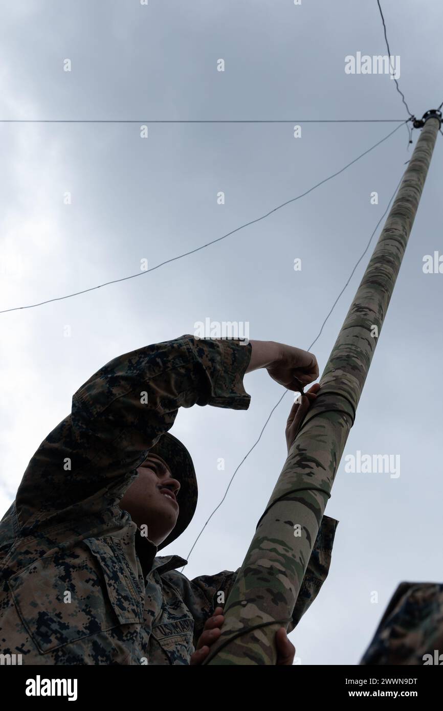 Heriberto Rayescandelario, un administrateur des systèmes de données de la 5th Air Naval Gunfire liaison Company, III Marine Expeditionary Force information Group, installe une radio lors d'un exercice de communication sur le terrain, Rapid Tanto à IE Shima, Okinawa, Japon, le 5 février 2024. La radio permettait la transmission de données au quartier général supérieur. À l'aide de radars prêts à l'emploi et d'équipements à faible signature, le 5e ANGLICO et le 3e bataillon du renseignement ont démontré leur compétence dans la planification, la coordination et l'exécution de ciblages dynamiques capables de soutenir des campagnes maritimes dans un contexte de plus en plus disputé Banque D'Images