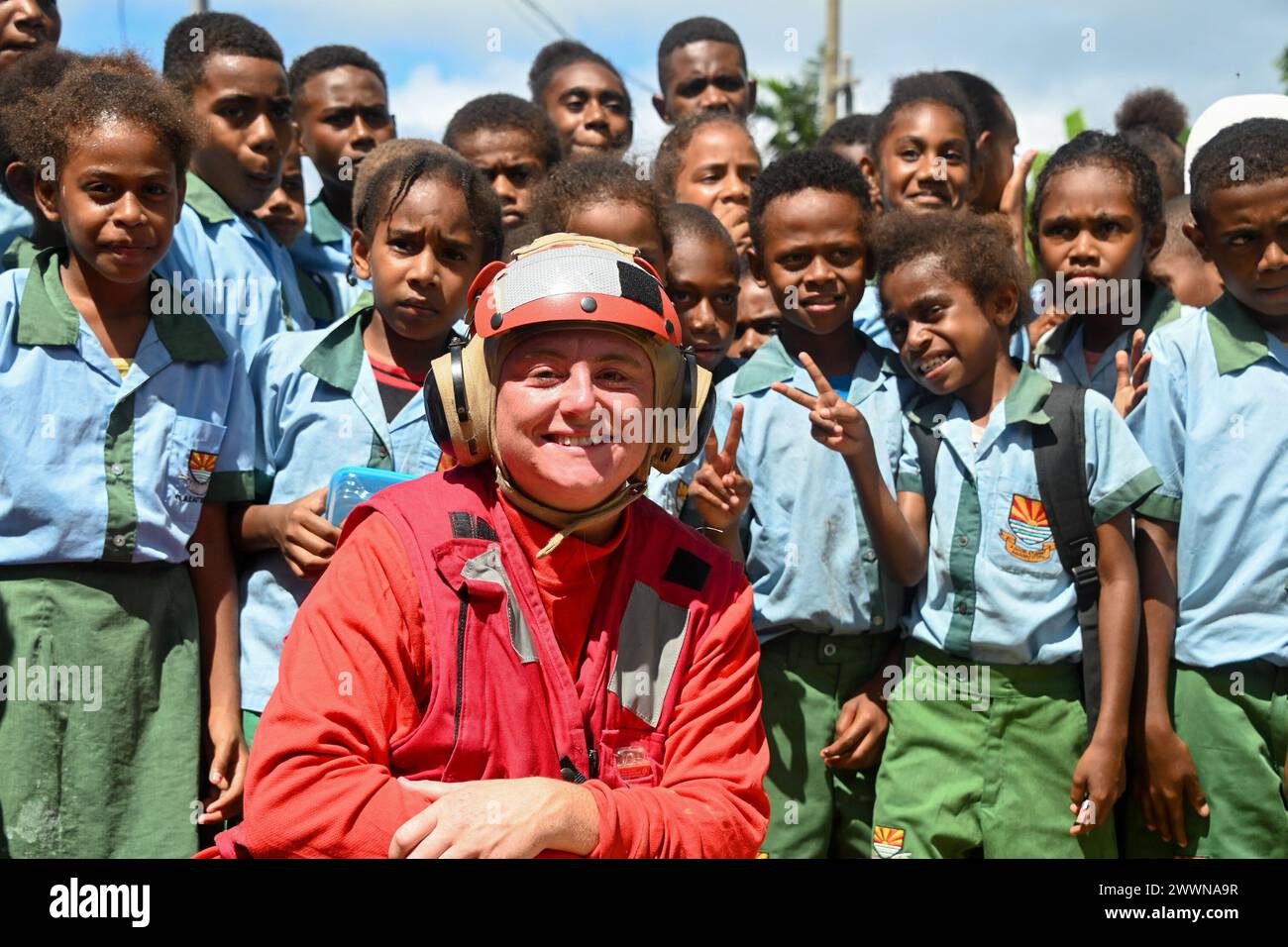 Shelby Averill, un officier de troisième classe de la Garde côtière américaine, un membre d'équipage du couturier de la Garde côtière américaine Harriet Lane (WMEC 903), pose avec un groupe d'écoliers de Vila East à Port Vila, Vanuatu, le 29 février 2024. Les membres de l’équipage de Harriet Lane ont visité deux écoles à Port Vila pour renforcer les liens avec la communauté locale et partager les connaissances culturelles entre les deux pays. Garde-côtes Banque D'Images