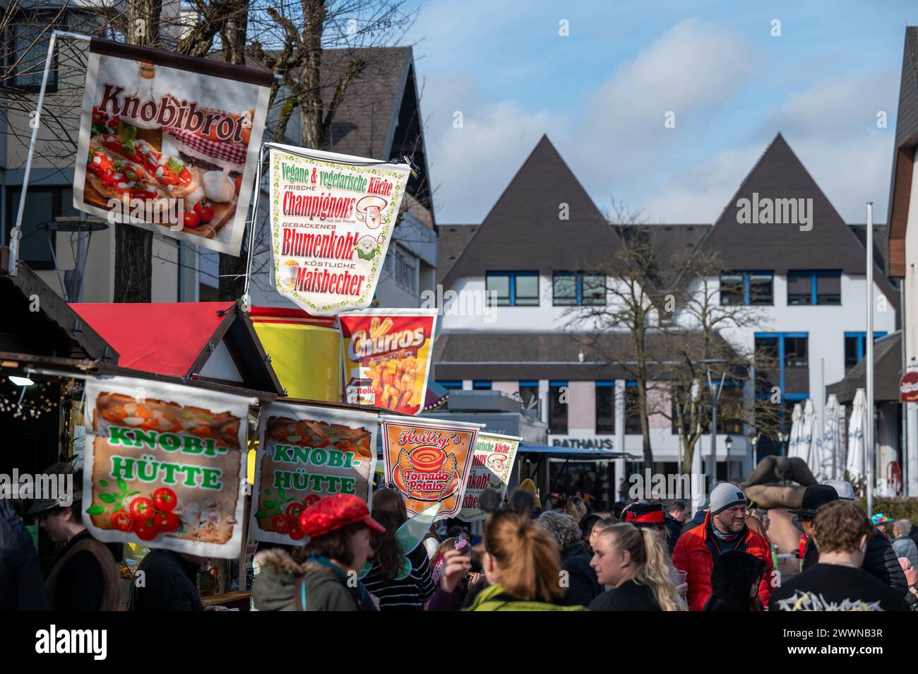 Une foule se dresse près de vendeurs de nourriture et de boissons lors de la 73e édition annuelle de Ramstein Fasching Parade à Ramstein-Miesenbach, Allemagne, le 13 février 2024. Le défilé annuel est le plus grand de la région de Westpfalz avec plus de 14 000 participants et amateurs de paradis. Armée de l'air Banque D'Images