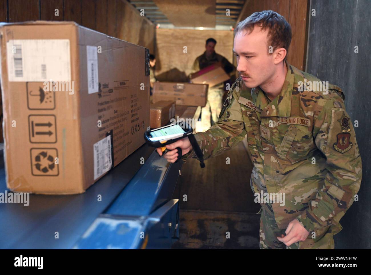 Airman 1st Class de l'US Air Force Michael Jones, commis postal militaire du 100th Force support Squadron, scanne les colis entrants lorsqu'ils sortent d'un camion sécurisé, s'assurant qu'ils sont enregistrés sur le système de suivi du service postal des États-Unis avant d'être prêts pour les clients à Royal Air Force Mildenhall, Angleterre, le 2 février, 2024. L’équipe de commandement de la 100th Air Reaveling Wing a visité le bureau de poste pour une immersion afin de voir par elle-même le processus qui permet aux clients de l’équipe Mildenhall de recevoir et d’envoyer du courrier. Armée de l'air Banque D'Images