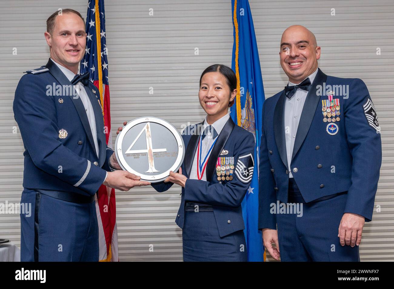 Le Sgt-maître Kaythi Rasay, centre, chef de la section des services alimentaires du 4e Groupe de soutien à la mission, reçoit le Prix du sous-officier supérieur de l'année des mains de Col. Lucas Teel, commandant de la 4e escadre de chasse et du Sgt-maître Peter Martinez, chef du commandement du 4e FW, lors de la cérémonie de remise des prix annuels 4 FW et du banquet à la base aérienne Seymour Johnson, Caroline du Nord, le 9 février 2024. Les prix annuels sont décernés aux aviateurs et aux civils dans 13 catégories différentes, y compris bénévole de l'année, sous-officier principal de l'année, conjoint clé de l'année, aviateur de l'année et plus encore. Armée de l'air Banque D'Images