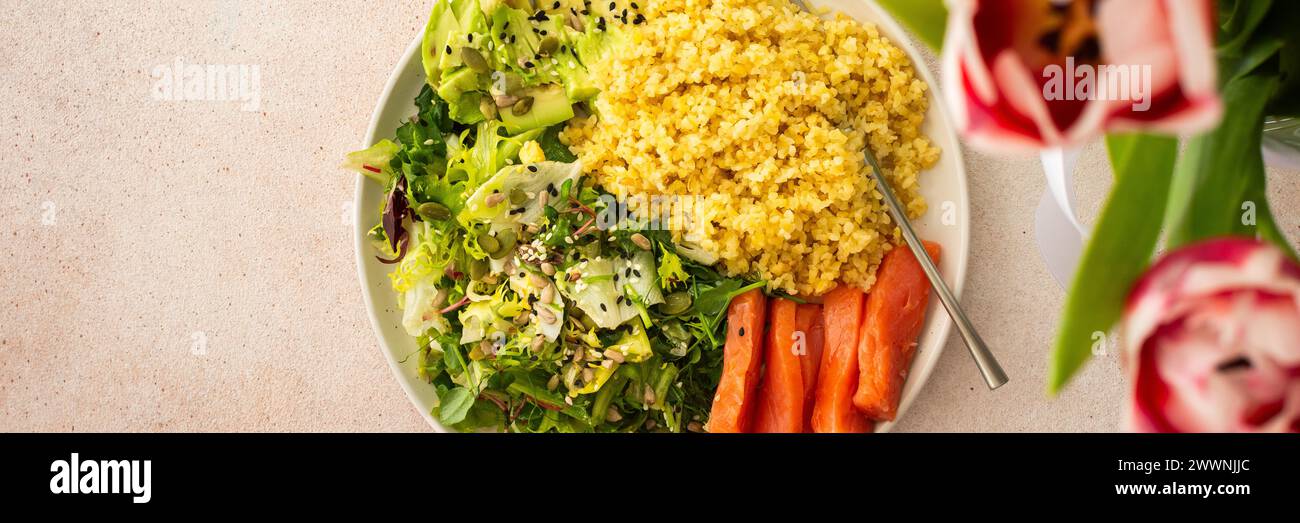 Délicieux petits déjeuners sains, bouillie de bulgur au poisson de saumon rouge et un mélange de salade avec des légumes frais, de l'avocat et diverses graines, un équilibre sain Banque D'Images