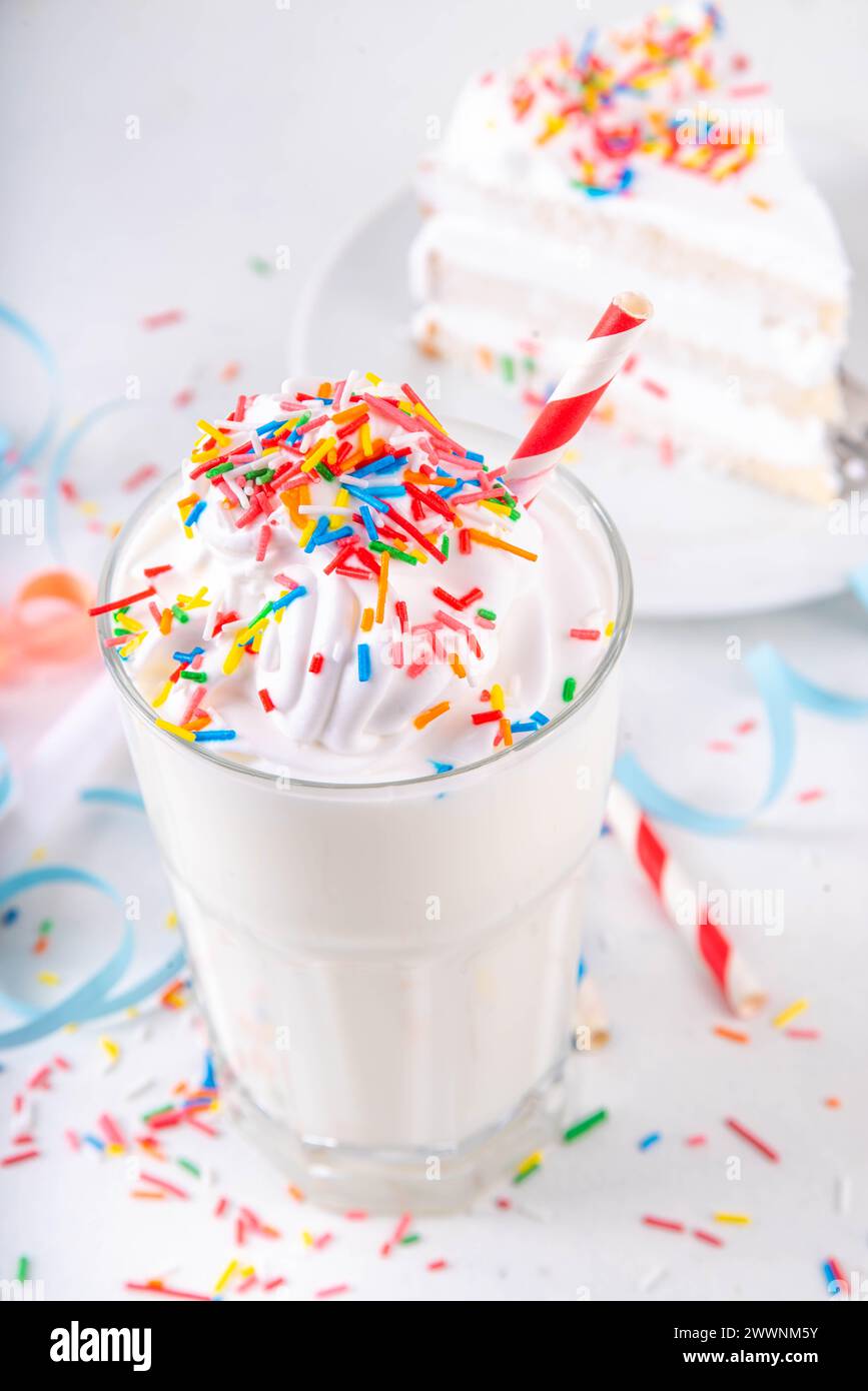 Gâteau d'anniversaire milkshake ou smoothie. Gâteau d'anniversaire maison glacé glace à la vanille blanche glacée cocktail flottant avec crème fouettée, et colorés s. Banque D'Images