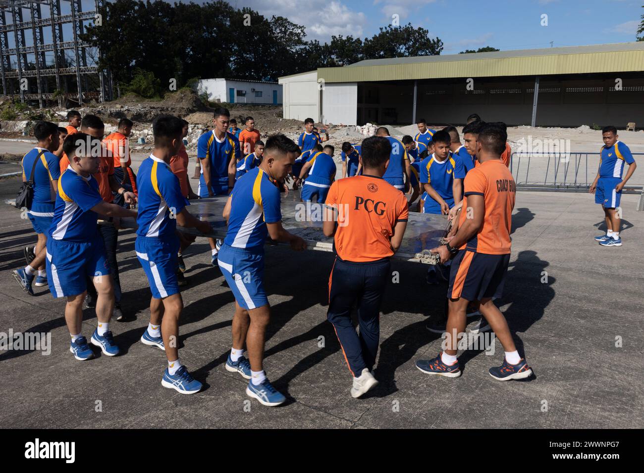 Les militaires philippins et les membres des gardes-côtes positionnent des palettes pour sécuriser les colis alimentaires familiaux du Département de la protection sociale et du développement en préparation pour le transport à la base aérienne de Villamor, Pasay City, Philippines, 11 février 2024. À la demande du gouvernement des Philippines, les Marines of III Marine Expeditionary Force des États-Unis soutiennent l'Agence des États-Unis pour le développement international dans la fourniture d'une aide humanitaire étrangère à la mission de secours en cas de catastrophe en cours à Mindanao. La présence avancée et la posture prête des moyens du MEF III dans la région ont facilité la rapidité et l'efficacité Banque D'Images