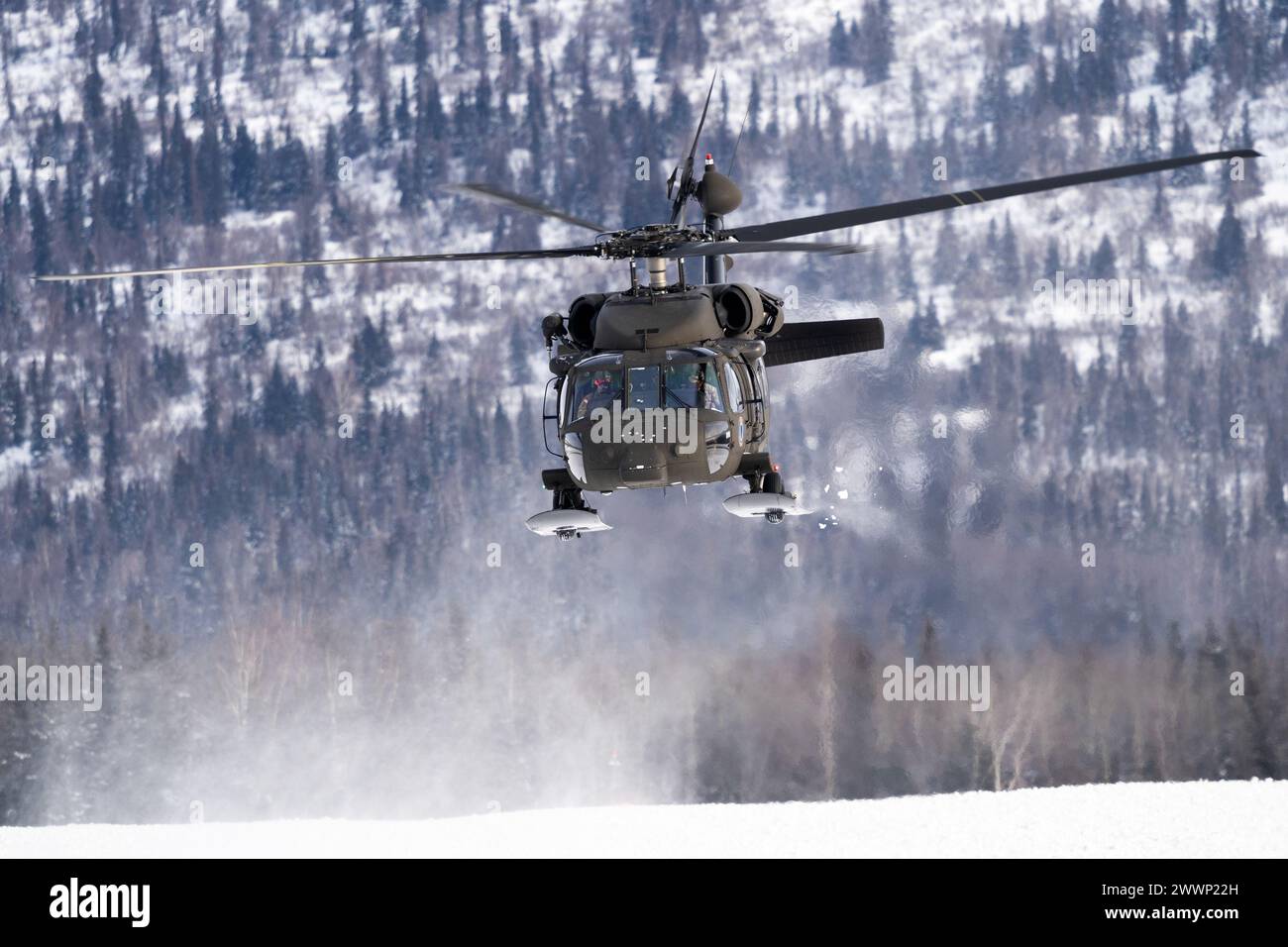 Le Capitaine de la Garde nationale de l'Alaska Cody McKinney, à gauche, et l'Adjudant-chef 3 Michael Miller, pilotent un hélicoptère UH-60L Black Hawk au-dessus de l'aérodrome de l'armée de Bryant tout en soutenant l'entraînement de charge à élingue à la base interarmées Elmendorf-Richardson, Alaska, le 28 février 2024. Des soldats de l’armée américaine du bataillon de l’aviation de la Garde nationale de l’Alaska ont mené l’entraînement par élingue afin d’améliorer leur capacité à opérer dans l’environnement difficile de l’Alaska. (Alaska National Guard Banque D'Images