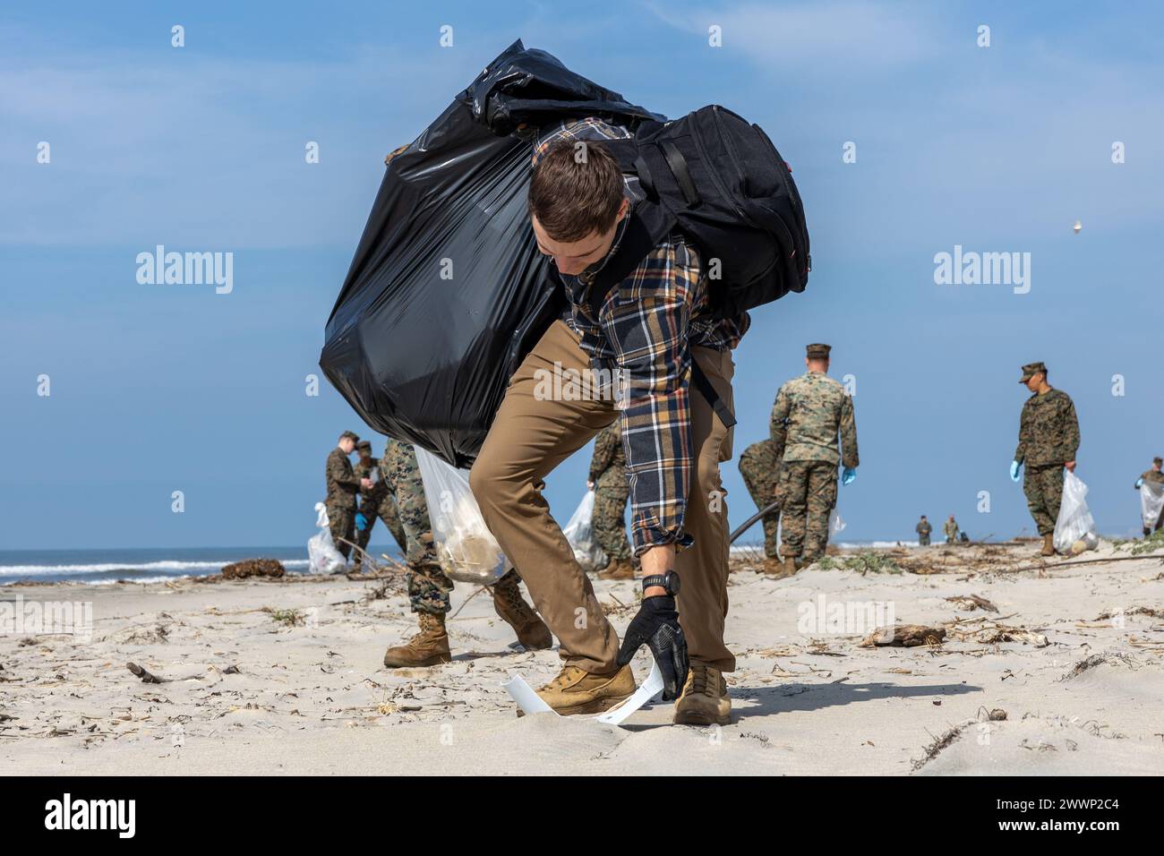 Chase Conrad, le chef des déchets dangereux du Marine corps base Camp Pendleton Environmental Security Department, recueille un morceau de déchets lors d'un nettoyage de plage à White Beach au MCB Camp Pendleton, Californie, le 16 février 2024. Ce nettoyage permet à MCB Camp Pendleton et à ses unités locatives de mener des efforts de préservation tout en harmonisant l’efficacité environnementale et la préparation militaire. MCB Camp Pendleton prend des mesures actives pour préserver la faune régionale et les ressources naturelles tout en fournissant à la Fleet Marine Force les espaces d’entraînement nécessaires pour répondre aux exigences en matière d’entraînement et de préparation. Ma Banque D'Images