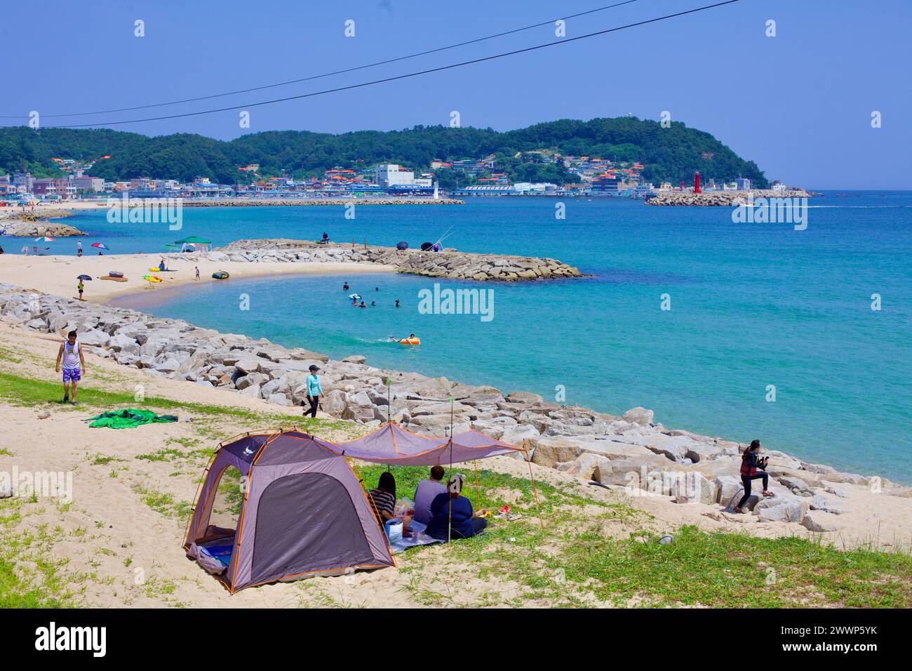 Comté de Goseong, Corée du Sud - 30 juillet 2019 : à l'extrémité nord de Geojin Village Beach, des rochers entourent le bord de l'eau avec un petit brise-lames de sable dans le Banque D'Images