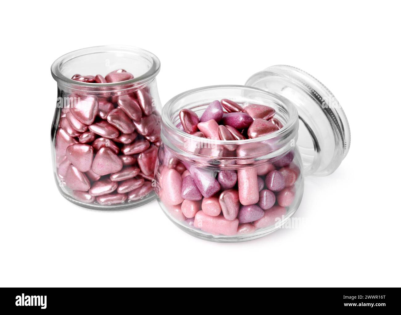 Savoureux bonbons roses dans des bocaux en verre isolés sur blanc Banque D'Images