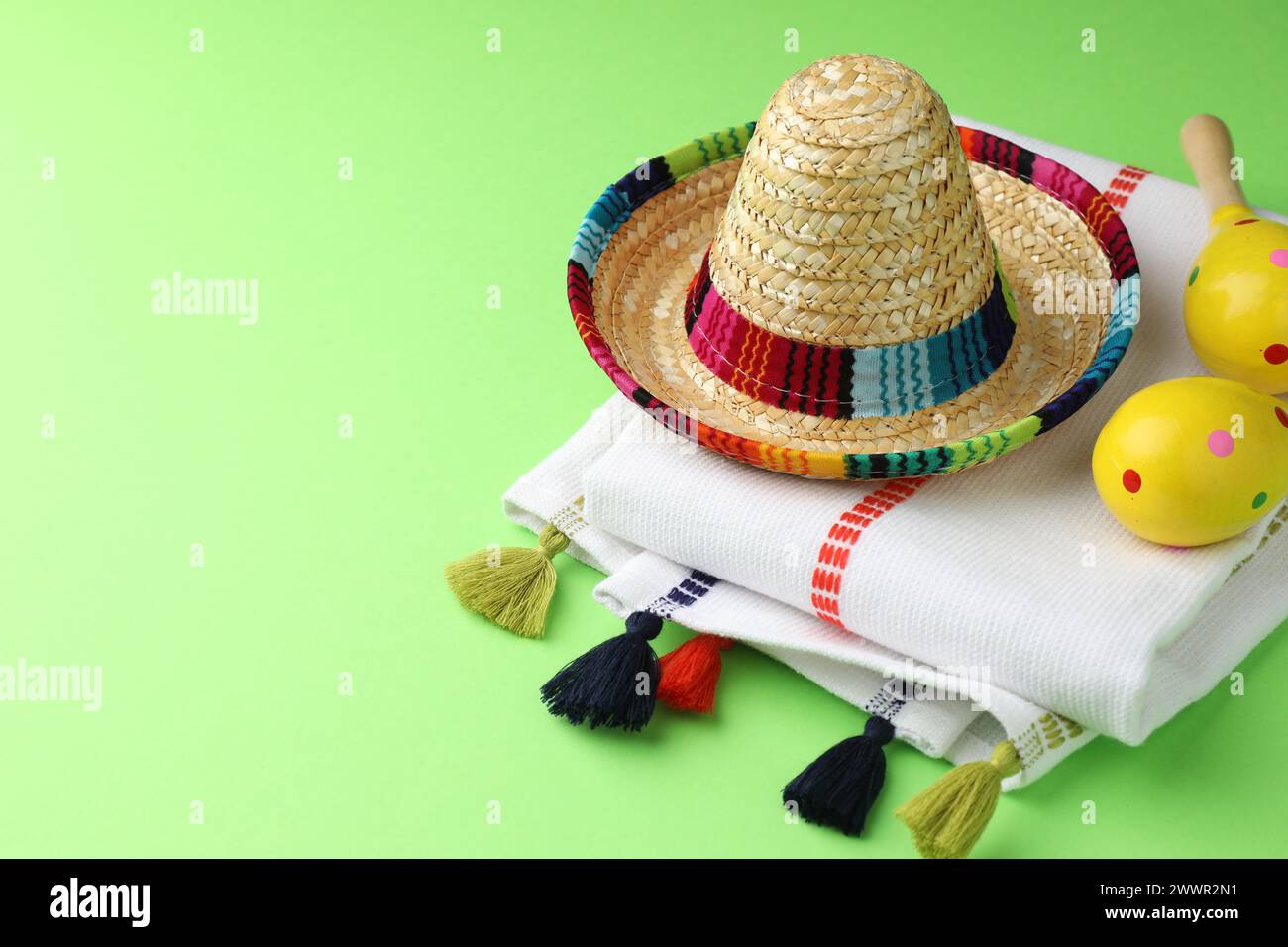 Chapeau sombrero mexicain, maracas et poncho sur fond vert. Espace pour le texte Banque D'Images