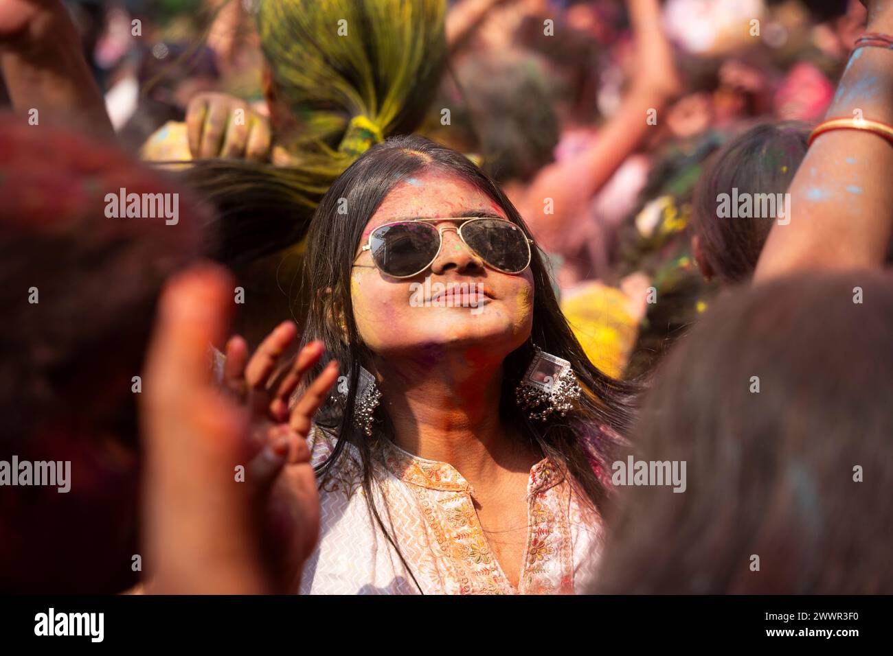 Guwahati, Assam, Inde. 25 mars 2024. Une fille dansant dans le rythme de la musique alors qu'elle célèbre Holi dans une rue, le festival hindou des couleurs du printemps le 25 mars 2024 à Guwahati, Assam, Inde. Holi, également connu sous le nom de Festival des couleurs ou Festival du printemps, est l'un des festivals les plus dynamiques et les plus joyeux en Inde. Crédit : David Talukdar/Alamy Live News crédit : David Talukdar/Alamy Live News Banque D'Images