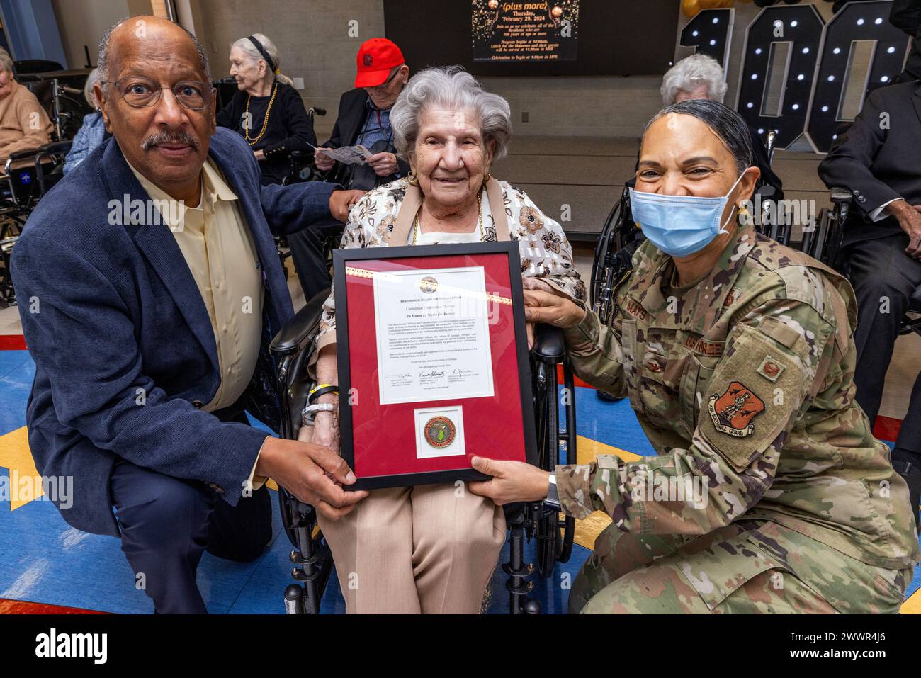 Gordon M. Johnson, sénateur de l'État du New Jersey, à gauche, et Yvonne L. Mays, adjudant général adjoint du New Jersey, à droite, présentent une lettre et une pièce de monnaie du Major Gen. Lisa J. Hou, D.O., adjudant général du New Jersey, à Marie DeMartine, un des 10 résidents de la New Jersey Veterans Memorial Home à Paramus, New Jersey, qui a récemment fêté son 100e anniversaire et, dans un cas, son 105e anniversaire, le 29 février 2024. Pendant la seconde Guerre mondiale, DeMartine travaille pour Ryan Aeronautical en Californie, construisant des avions pour l'effort de guerre. (Garde nationale du New Jersey Banque D'Images
