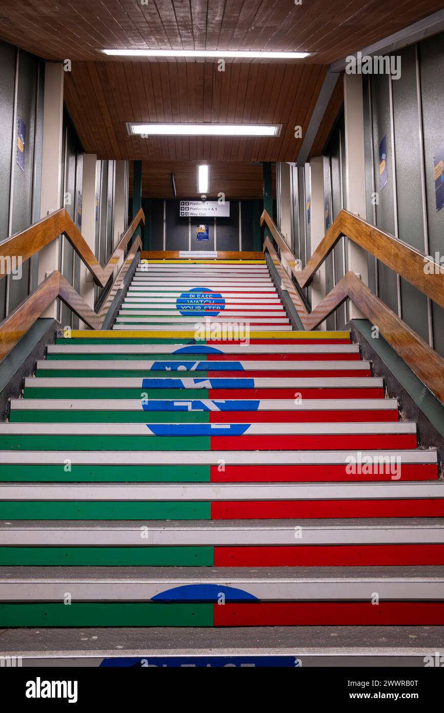 Escalier vert et rouge vibrant dans une gare de Manchester avec un plafond en bois et signalisation. Banque D'Images