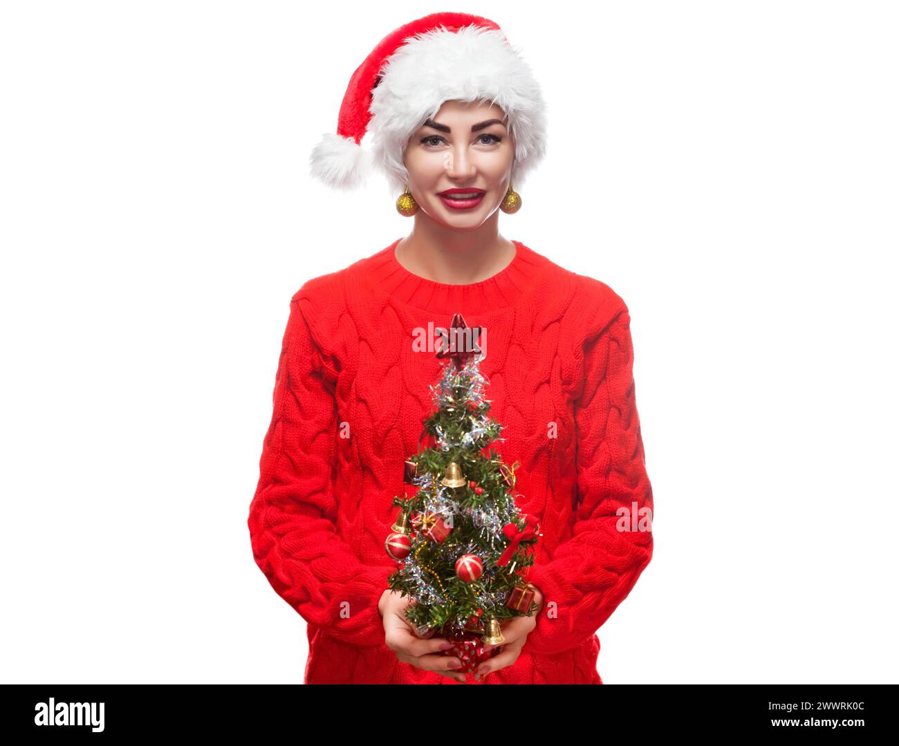 Portrait d'une belle femme dans un chapeau rouge et un pull avec un arbre de Noël sur un thème du nouvel an. Banque D'Images