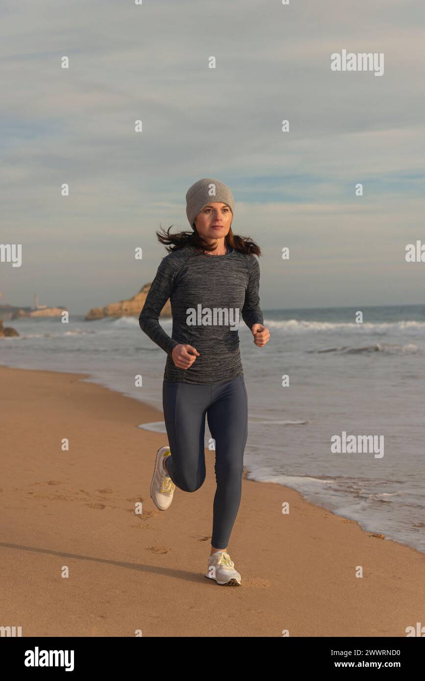 Fit femme sportive courir le long d'une plage. Banque D'Images