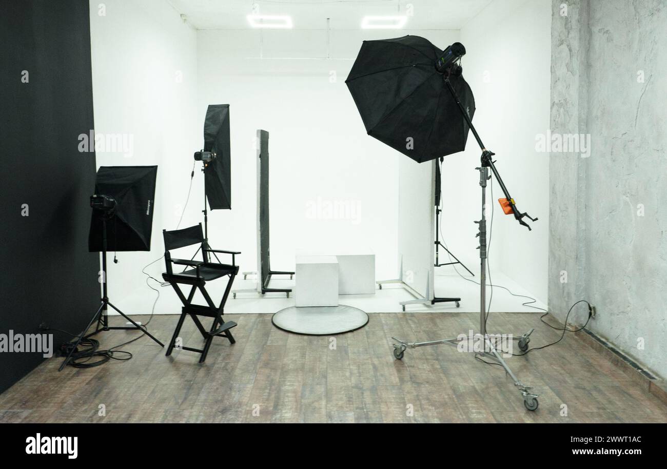Un studio avec une chaise, une table et une caméra. La scène est professionnelle et sérieuse Banque D'Images