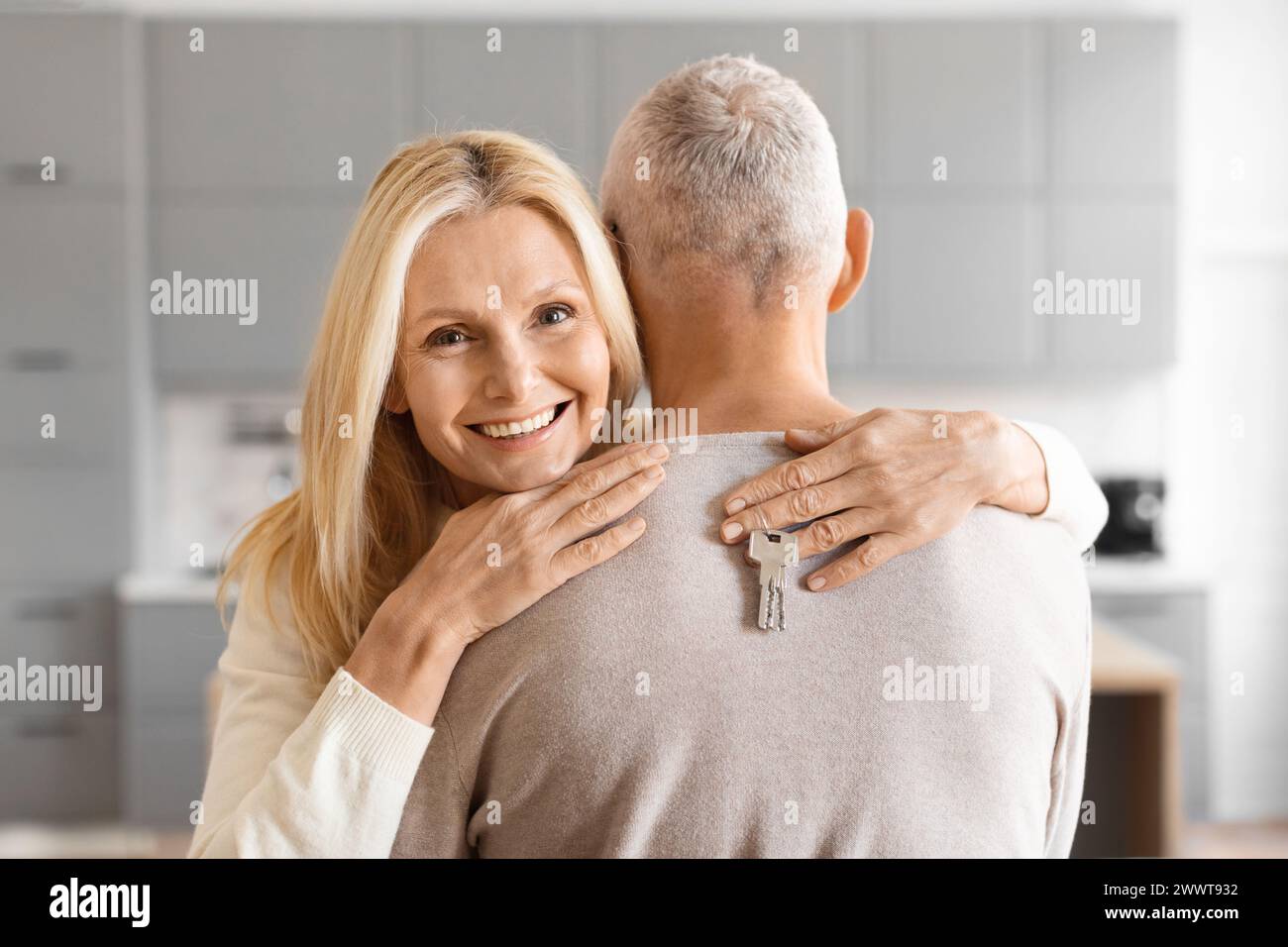 Couple embrassant avec la clé de la maison à la main Banque D'Images