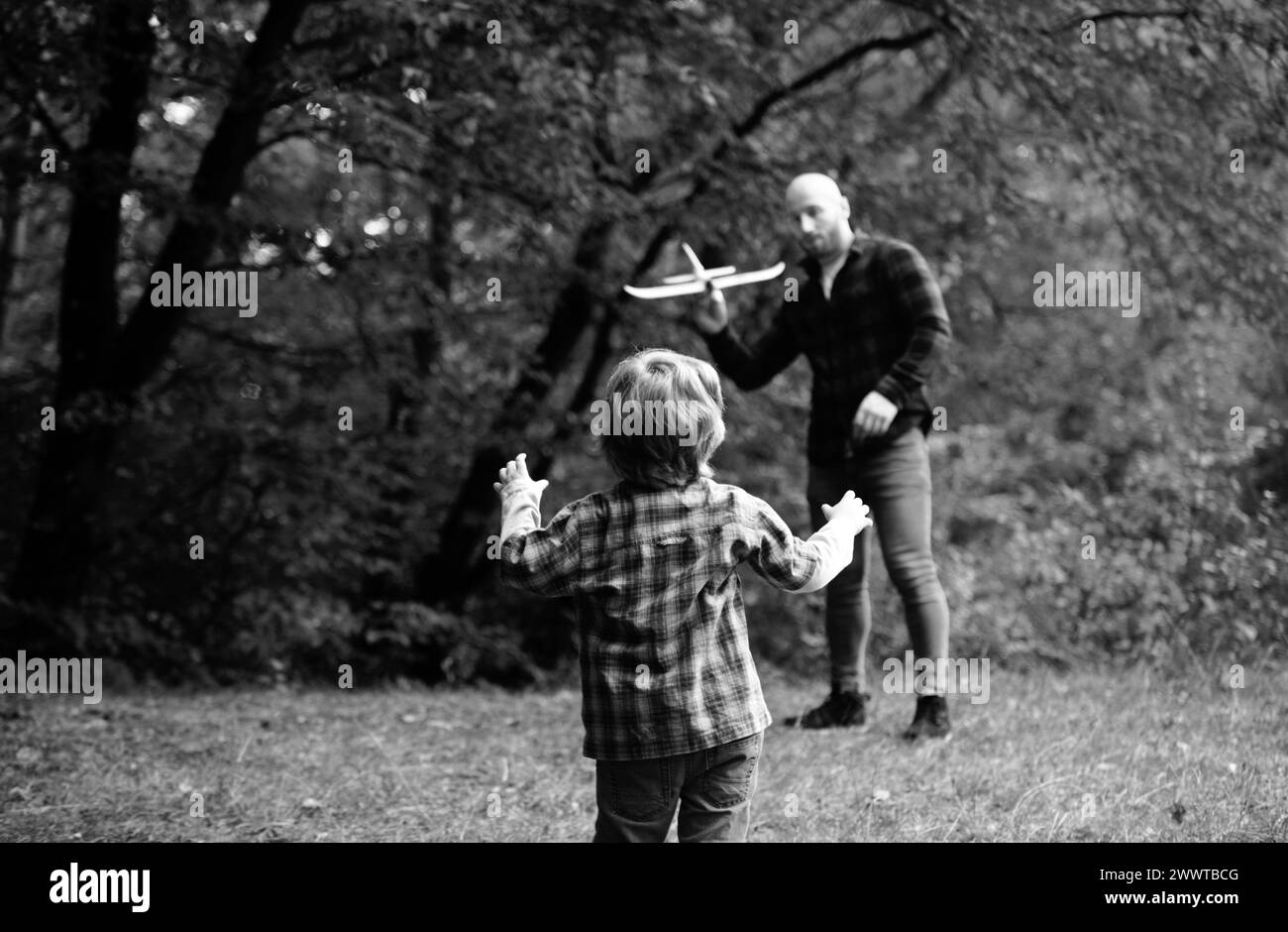 Enfant mignon avec papa jouer avec avion jouet. Fête des pères. Papa et bébé fils jouant ensemble à l'extérieur jouet avion. Banque D'Images