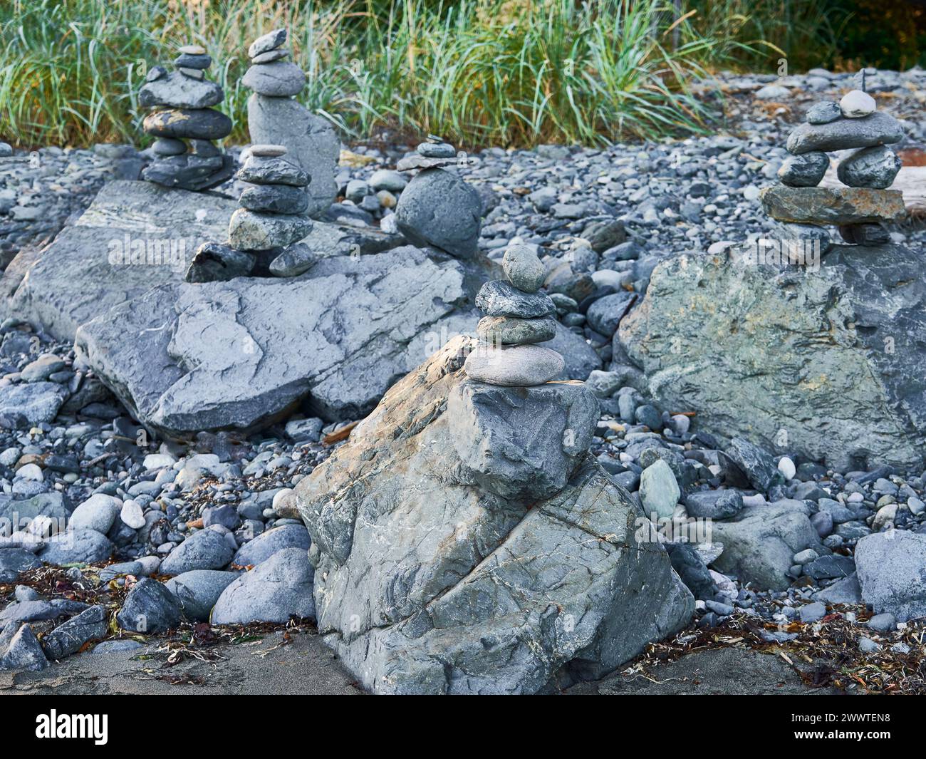 De nombreux inukshuks créés à partir de roches grises au sommet de rochers à Jordan River Beach Banque D'Images