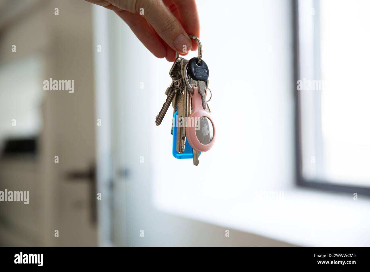 Gros plan de mains tenant des clés avec un AirTag Apple Banque D'Images