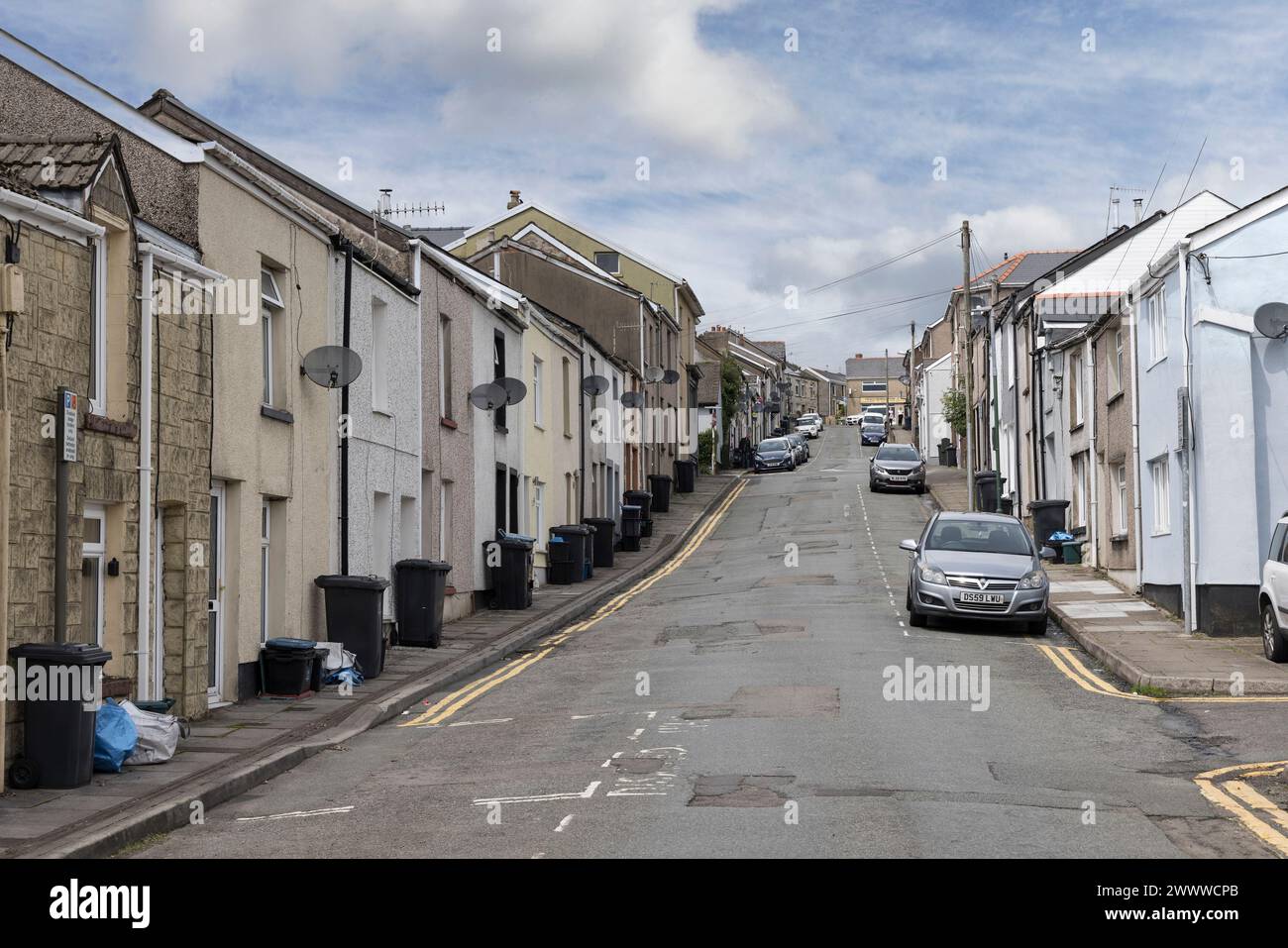 Rue avec maisons mitoyennes et poubelles sur le trottoir en attente de collecte, Brynmawr, pays de Galles, Royaume-Uni Banque D'Images