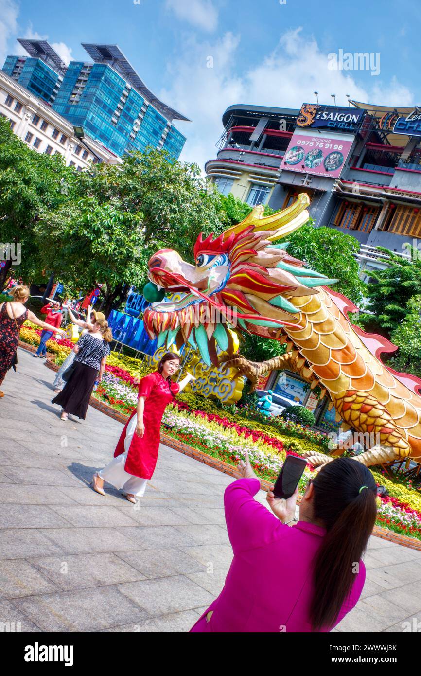 Les gens posent pour des photos sur la rue de fleurs de Nguyen Hue pendant les célébrations du Têt (nouvel an 2024), Ho Chi Minh ville, Vietnam Banque D'Images