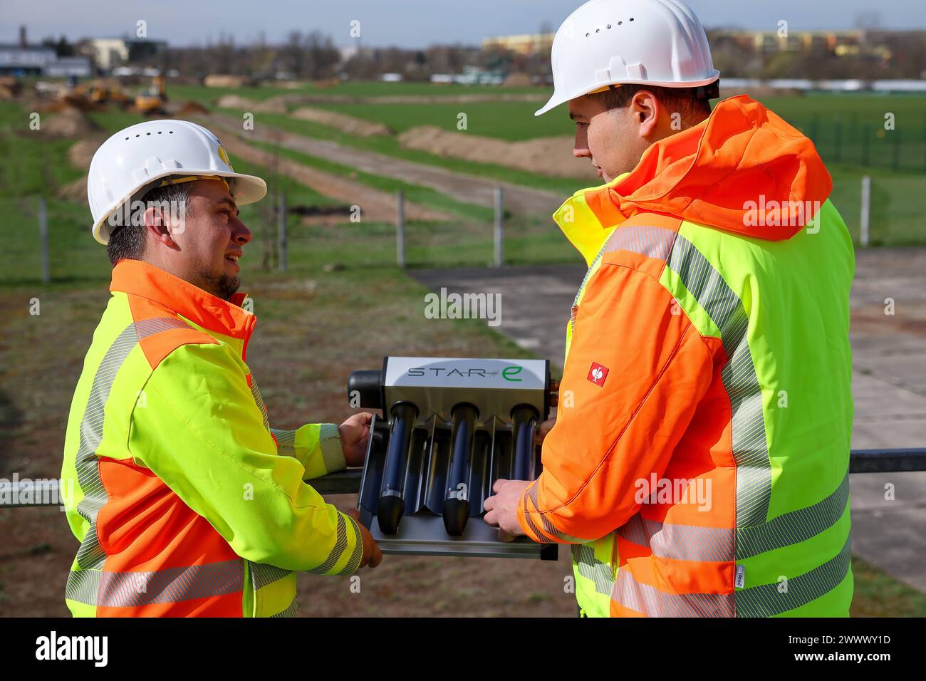 26 mars 2024, Saxe, Leipzig : les chefs de projet Guido Wimmer (à gauche) et Paul Gaspar de Ritter Energie présentent un échantillon d'un collecteur tubulaire évacué sur le chantier de construction d'une future centrale solaire thermique. Au cours des prochains mois, une centrale composée de 13 200 capteurs solaires sera construite dans la banlieue ouest de Leipzig. L'eau, chauffée à 108 degrés par le soleil, sera alimentée dans le circuit de chauffage urbain de la ville. Cela devrait couvrir 20% des besoins totaux de chauffage de Leipzig en été. Stadtwerke investit 40 millions d'euros dans l'usine. La chaleur doit être injectée à partir de 2026. P Banque D'Images