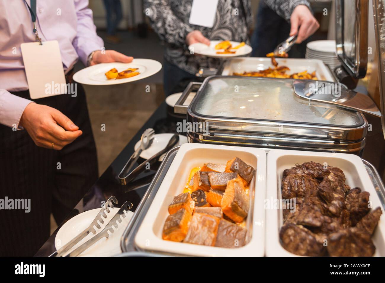 Les participants au séminaire d’affaires choisissent leur nourriture pendant leur pause déjeuner dans un restaurant buffet en libre-service Banque D'Images