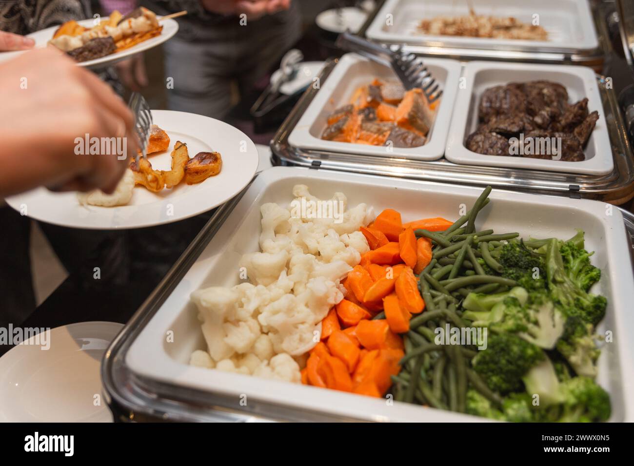 Les participants au séminaire d’affaires choisissent leur nourriture pendant leur pause déjeuner dans un restaurant buffet en libre-service Banque D'Images