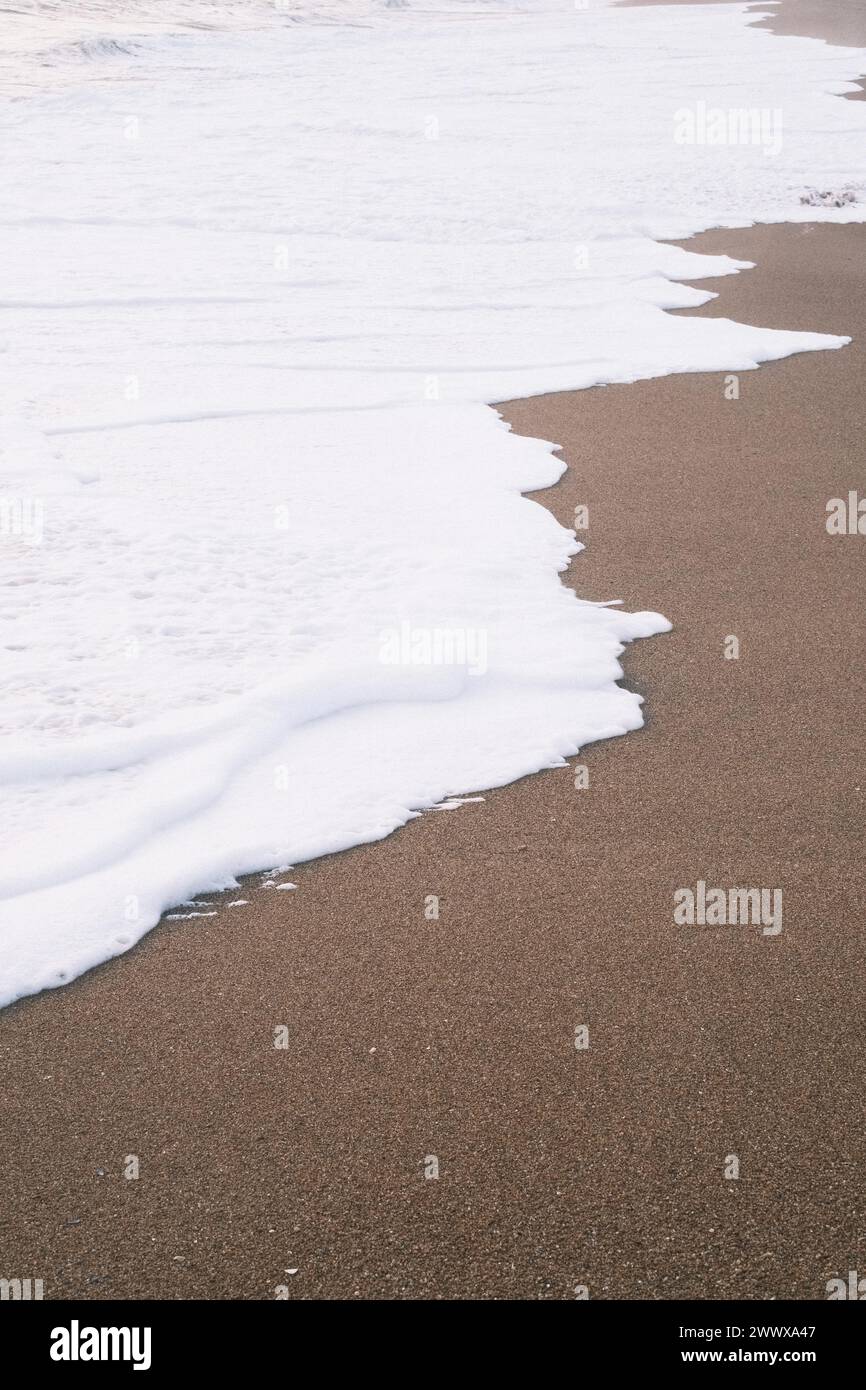 Une scène de plage de sable avec de l'écume blanche de l'océan Banque D'Images