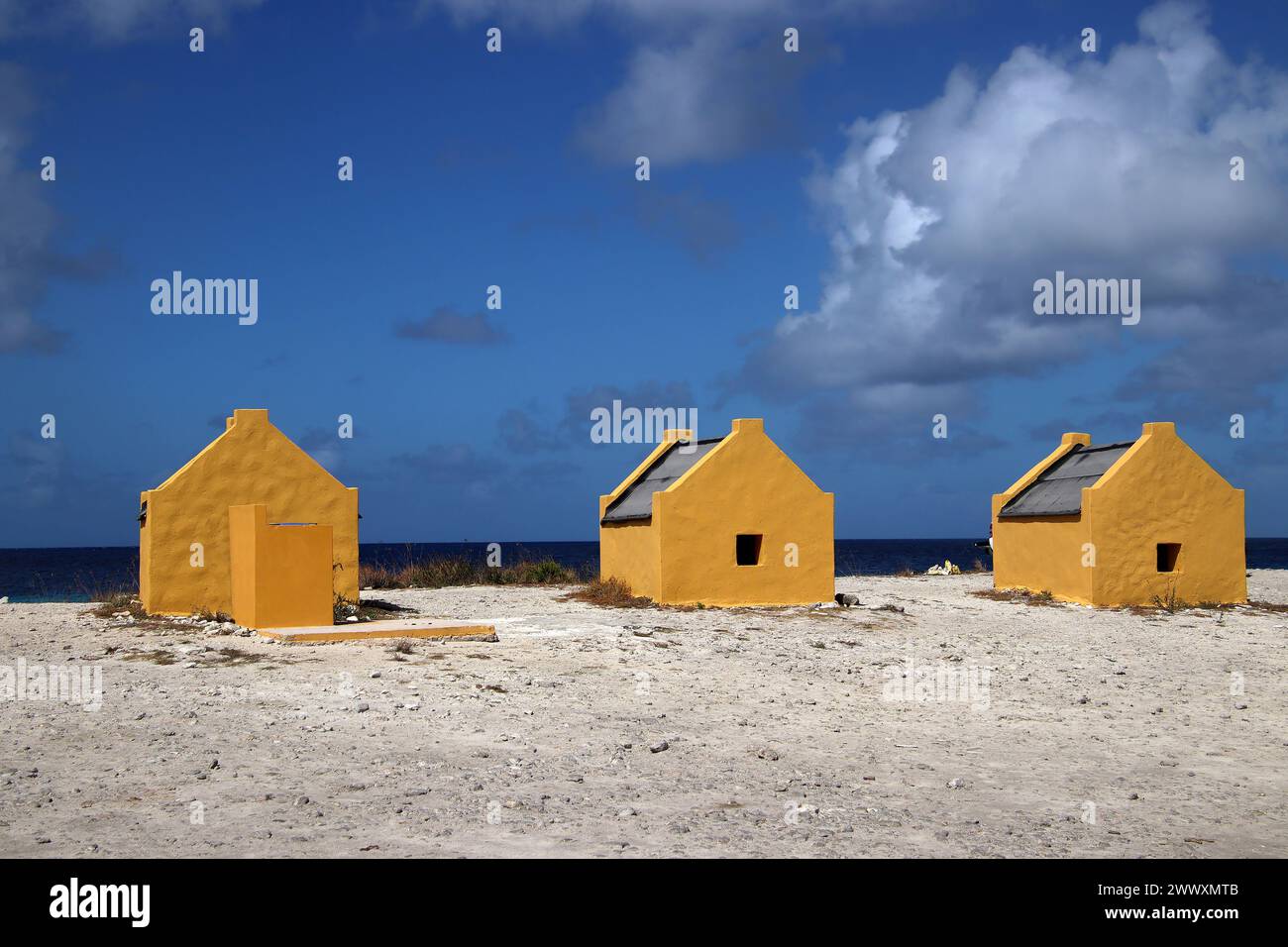Huttes d'esclaves jaunes contre ciel bleu - site historique sur l'île de Bonaire, pays-Bas des Caraïbes Banque D'Images