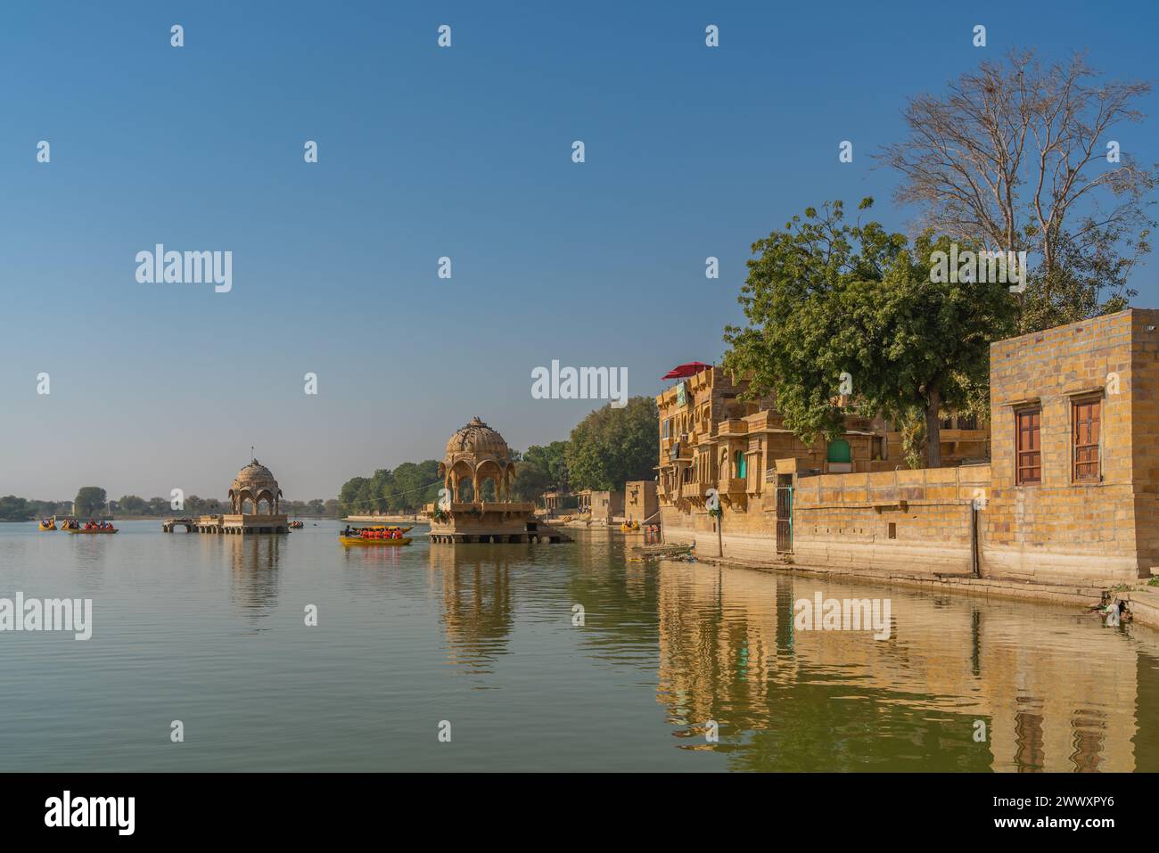 Jaisalmer, Inde - décembre 2023 : ancien temple au lac Gadisar Jaisalmer Rajasthan avec bateau touristique sur l'eau Banque D'Images