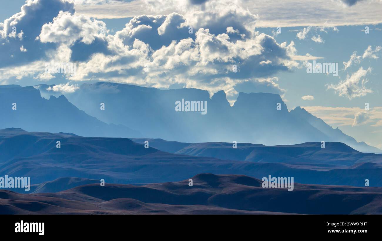 Dernière lumière de l'après-midi à travers les sommets bleus lointains des montagnes Drakensberg en Afrique du Sud. Banque D'Images