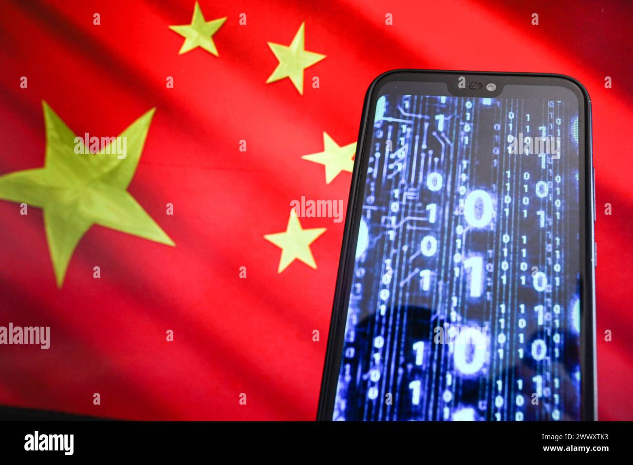Dans cette illustration photo, le code binaire est affiché sur un smartphone avec le drapeau de la Chine en arrière-plan. Banque D'Images