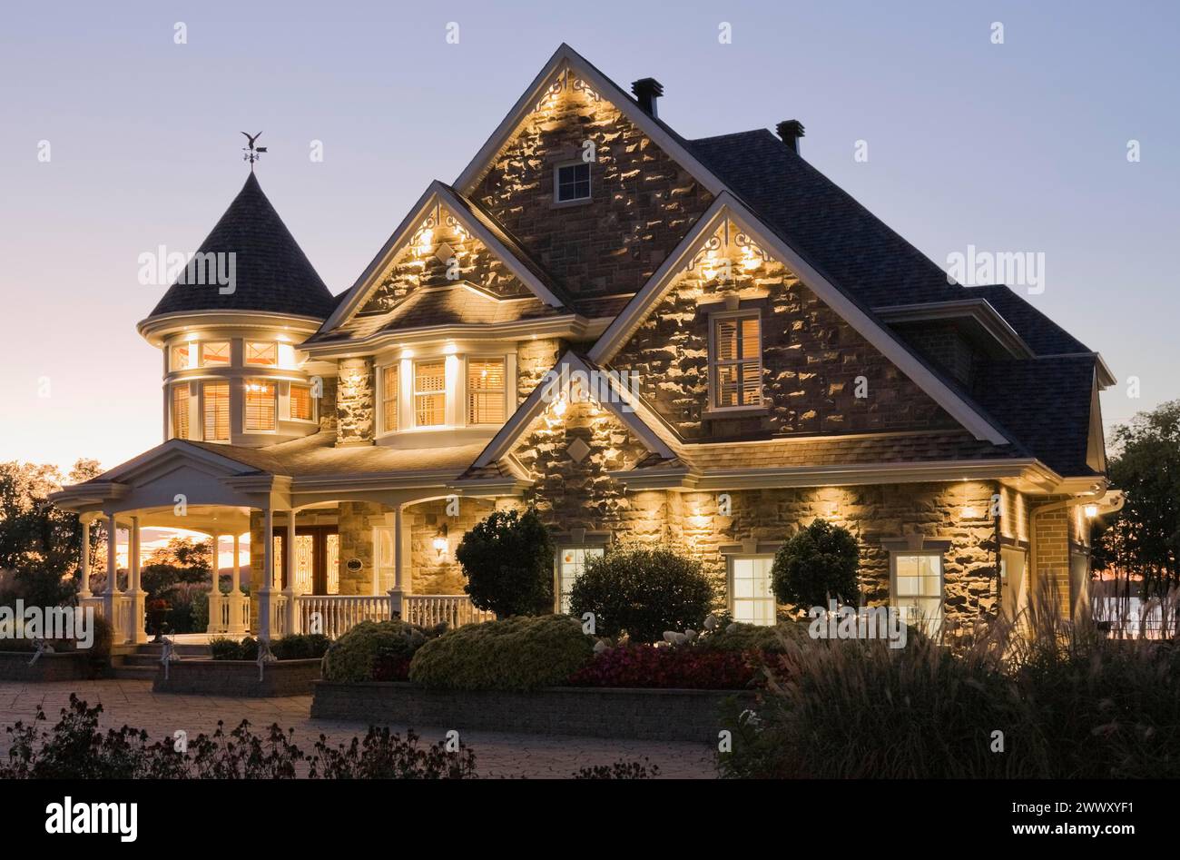 Élégante pierre grise avec garniture blanche et bardeaux d'asphalte bleu toit façade victorienne au crépuscule en été, Québec, Canada Banque D'Images