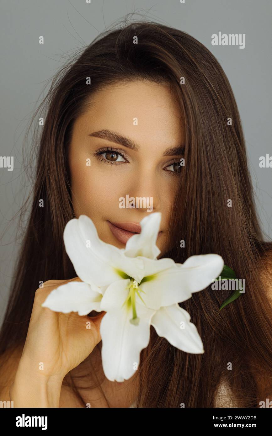 Visage de beauté de la jeune belle femme avec fleur sur fond blanc Banque D'Images