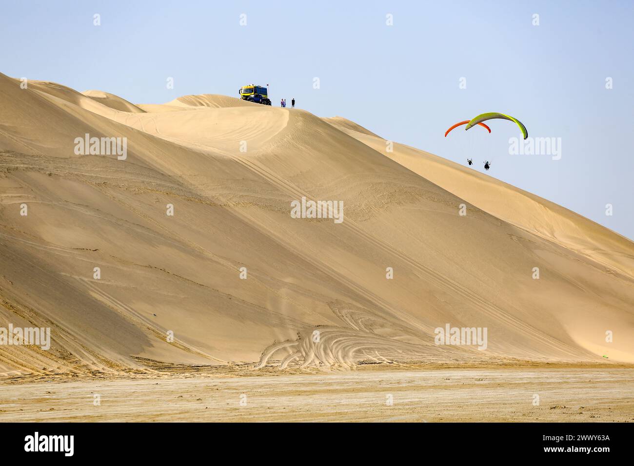 Parapente survolant les dunes de sable dans le désert qatari Banque D'Images