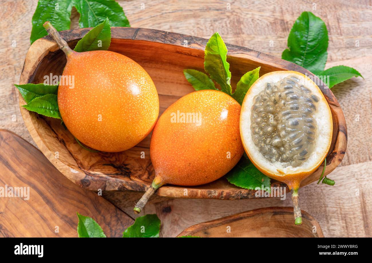 Fruits de Granadilla avec des feuilles sur la table en bois. Vue de dessus. Banque D'Images