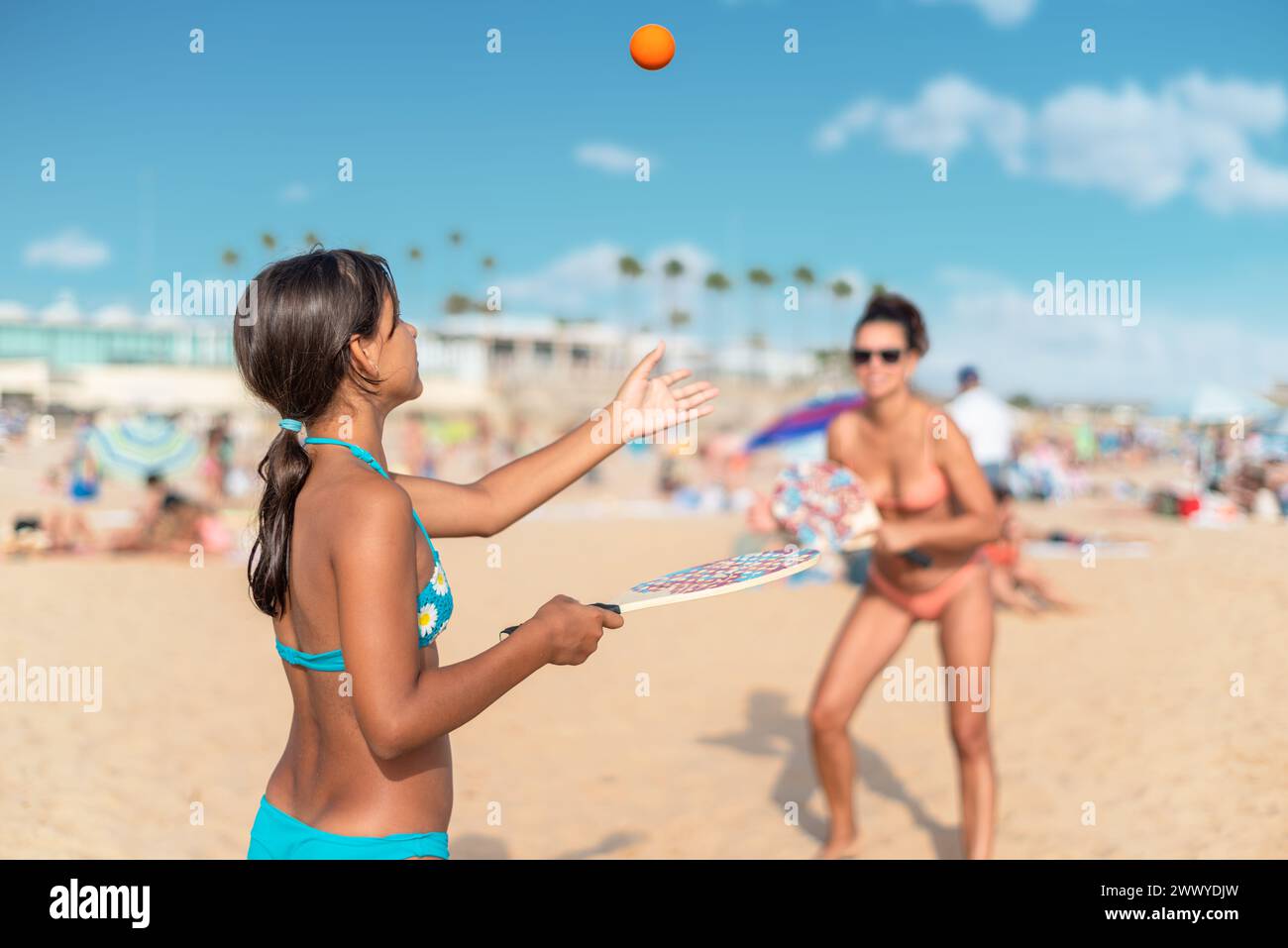 Maman et fille jouant au tennis de plage ou au padel à la plage. Banque D'Images