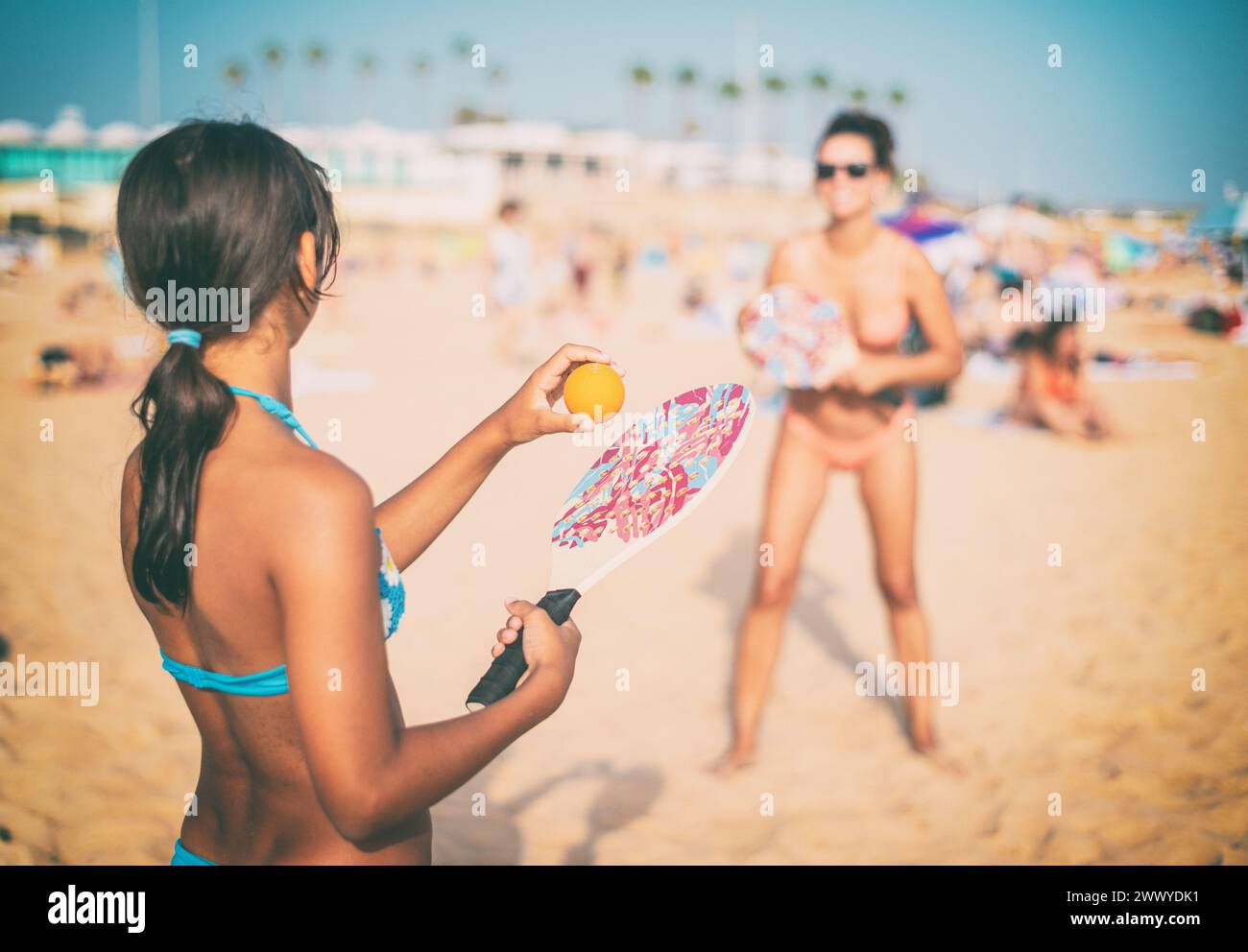 Maman et fille jouant au tennis de plage ou au padel à la plage. Banque D'Images