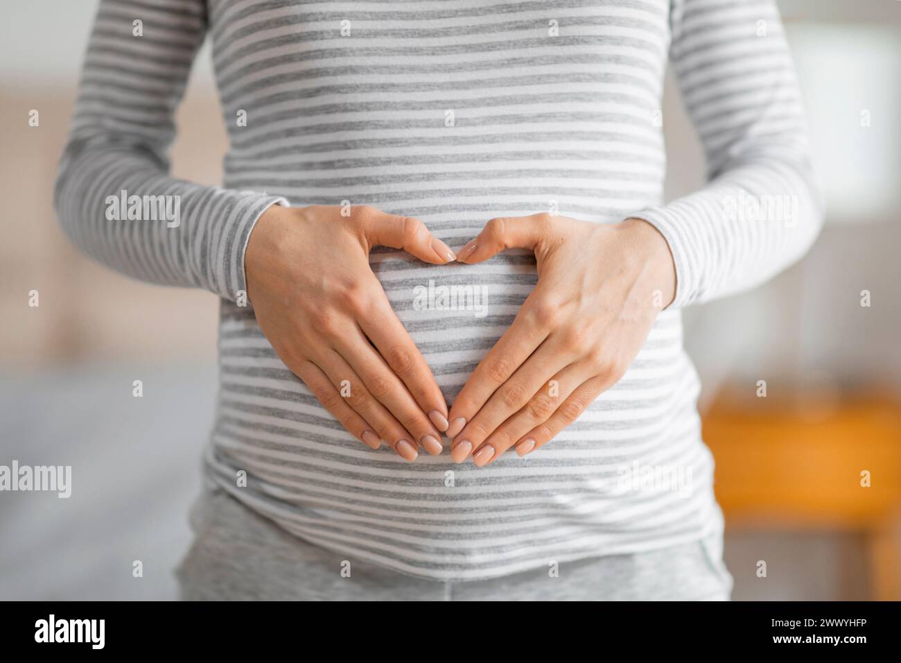 Femme enceinte formant une forme de coeur sur le ventre Banque D'Images
