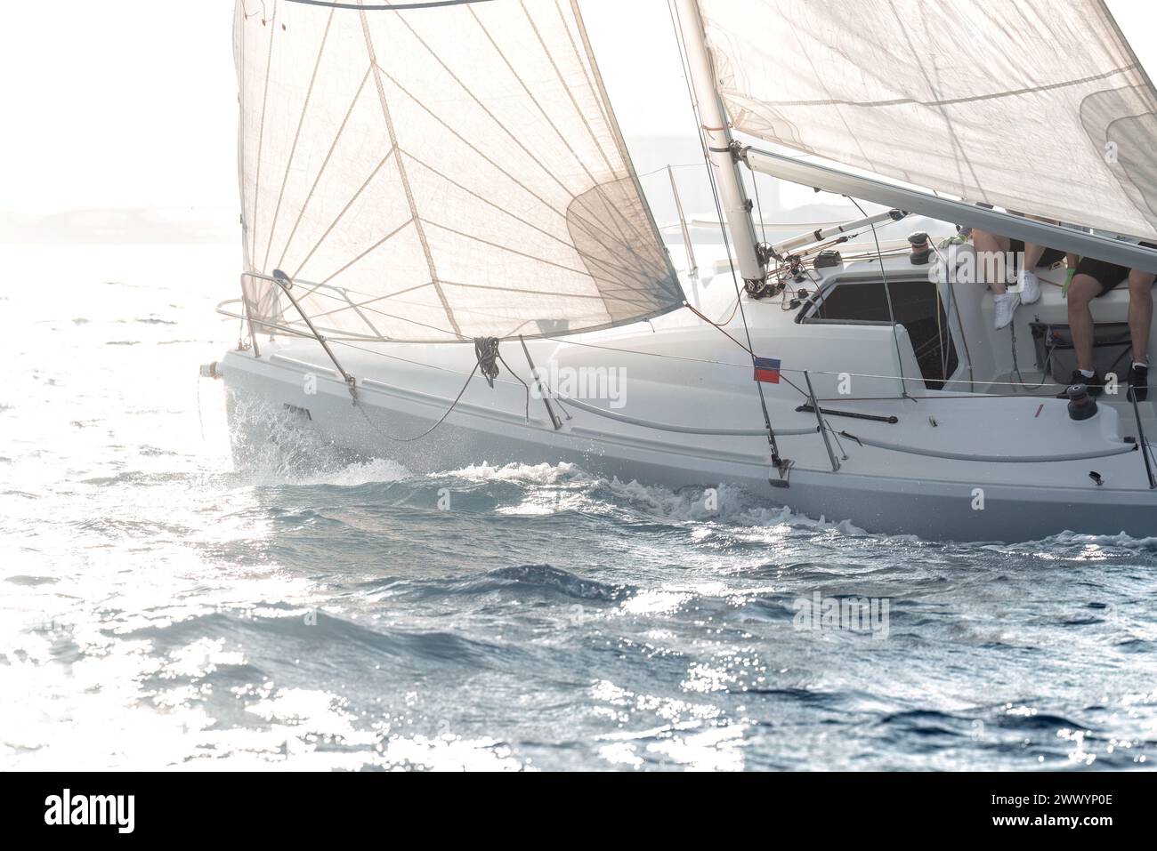 Voilier participant à une régate de yachting, glissant sur les eaux méditerranéennes au coucher du soleil Banque D'Images