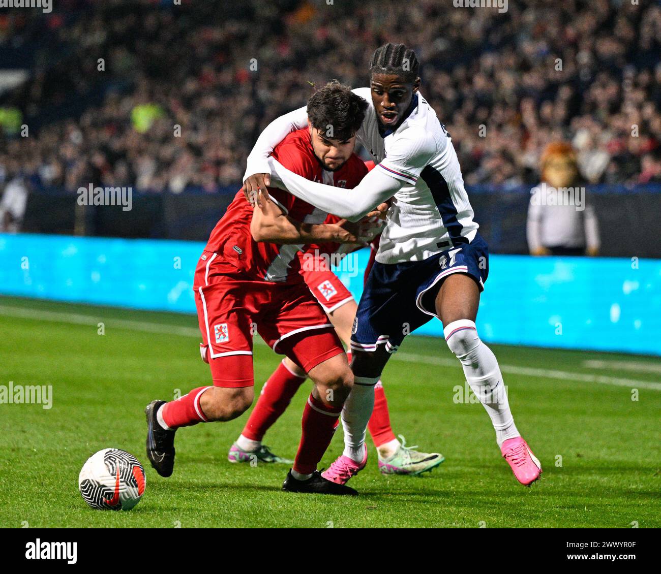 Bolton, Royaume-Uni. 26 mars 2024. Emre Erkus du Luxembourg et Samuel Iling-Junior de l'Angleterre s'affrontent pour le ballon, lors du match UEFA Euro U21 qualificatifs du Groupe F Angleterre U21 vs Luxembourg U21 au Toughsheet Community Stadium, Bolton, Royaume-Uni, le 26 mars 2024 (photo Cody Froggatt/News images) à Bolton, Royaume-Uni, le 26/03/2024. (Photo de Cody Froggatt/News images/Sipa USA) crédit : Sipa USA/Alamy Live News Banque D'Images