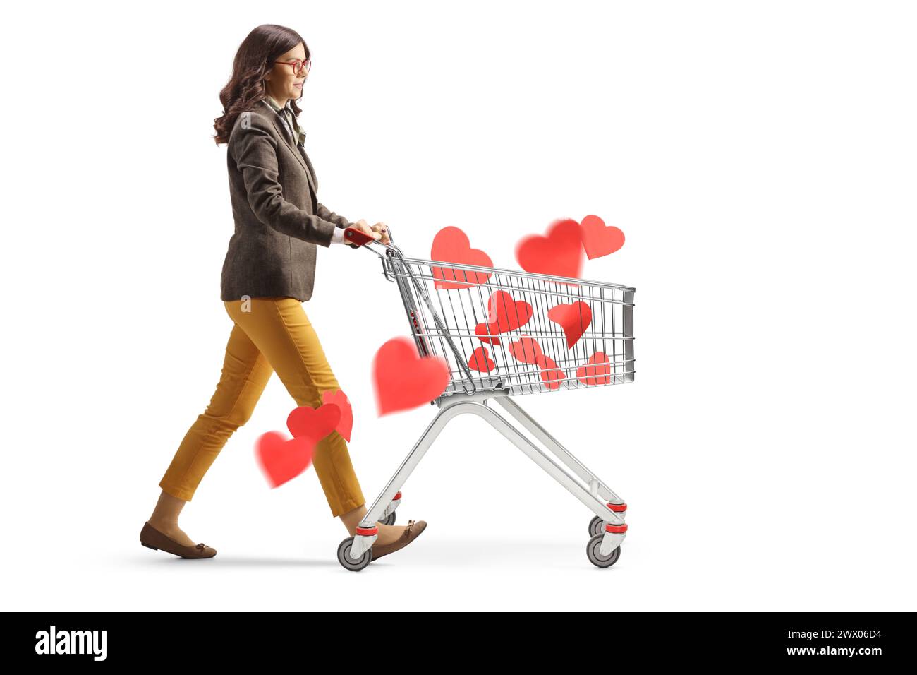 Plan de profil pleine longueur d'une jeune femme professionnelle marchant avec un chariot avec des cœurs rouges isolés sur fond blanc Banque D'Images