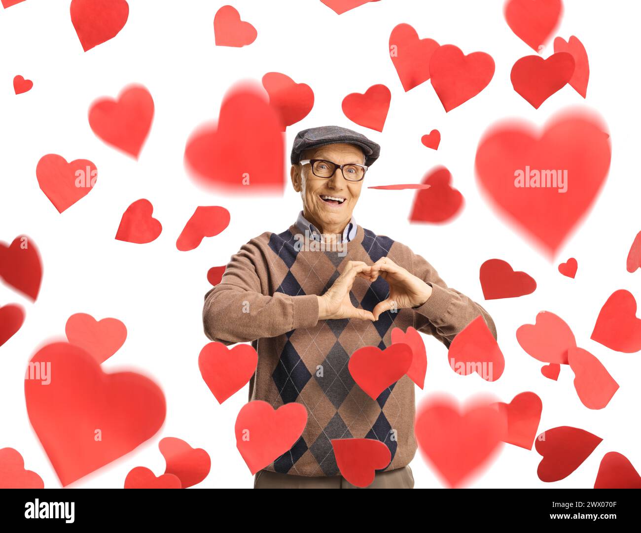 Homme âgé gestionnant un signe de coeur sous des cœurs tombants isolés sur fond blanc Banque D'Images