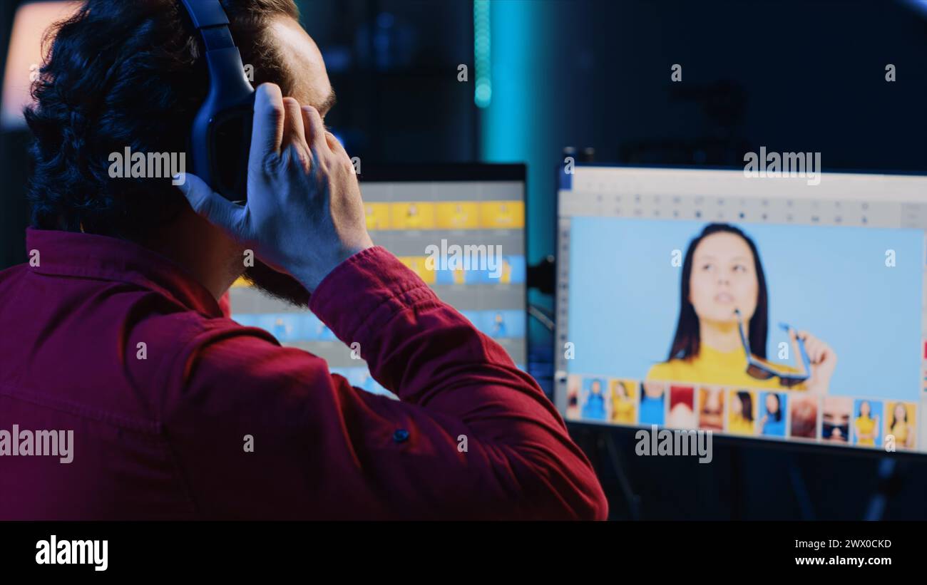 Retouche d'images indépendant éclairage et balance des couleurs, travaillant dans le home studio tout en écoutant de la musique. Photographe utilisant un casque pour écouter ses chansons préférées tout en utilisant un logiciel de retouche Banque D'Images