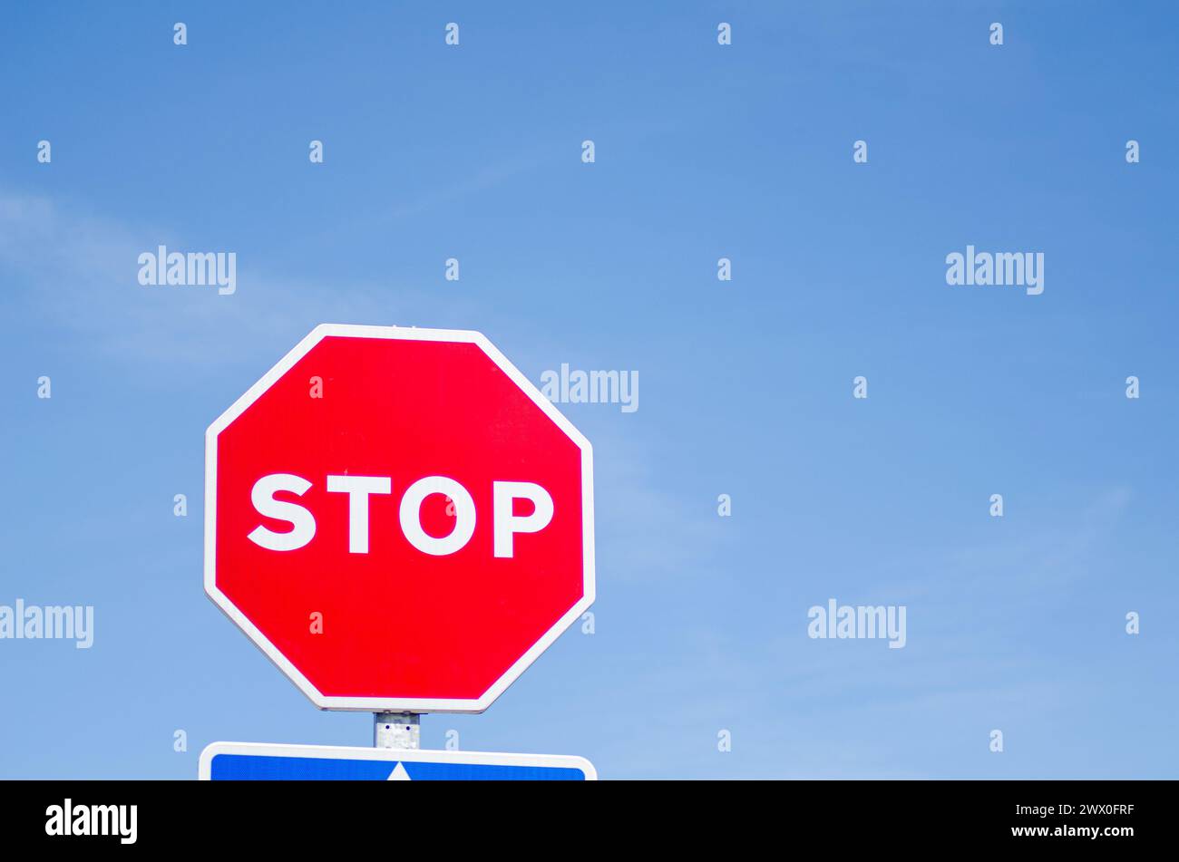 panneau d'arrêt isolé avec fond de ciel bleu, sécurité routière Banque D'Images