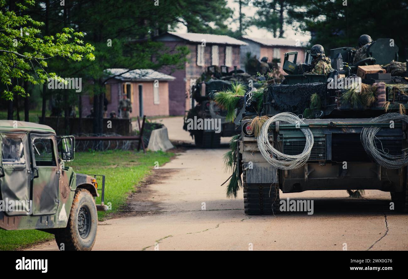 Les soldats de l'armée américaine affectés au 3e bataillon, 69e régiment d'armure, 1re brigade blindée combat Team, 3e division d'infanterie, engagent une force ennemie simulée au joint Readiness Training Center (JRTC) à Fort Johnson, en Louisiane, le 18 mars 2024. Les équipages de chars se sont entraînés avec des unités d'infanterie blindées légères pour augmenter leur létalité dans différents environnements pendant leur entraînement de deux semaines au JRTC. (Photo de l'armée américaine par le PFC Luciano Alcala) Banque D'Images